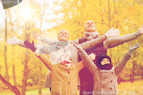 Image of happy family having fun in autumn park