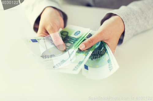 Image of close up of woman hands counting euro money