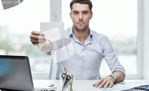 Image of businessman showing blank paper card at office