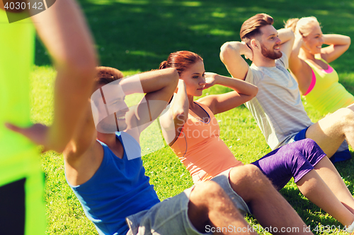 Image of group of friends or sportsmen exercising outdoors