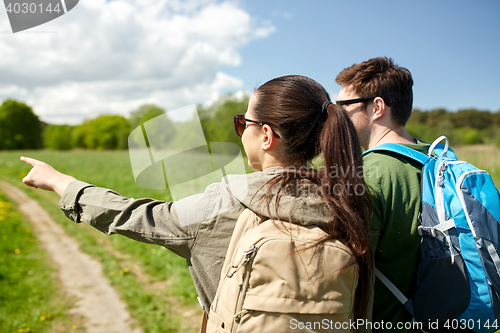 Image of happy couple with backpacks hiking outdoors