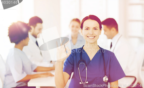 Image of happy doctor over group of medics at hospital