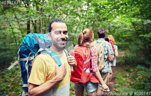 Image of group of smiling friends with backpacks hiking