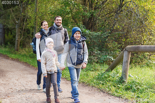 Image of happy family with backpacks hiking in woods