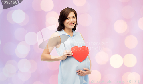 Image of happy pregnant woman with red heart touching belly