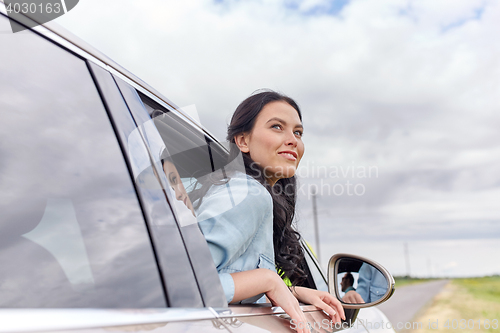 Image of happy young woman driving in car