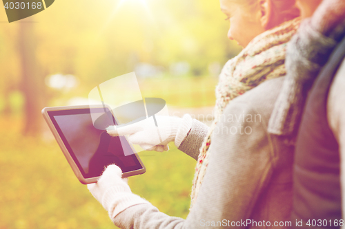 Image of couple hands in gloves with tablet pc outdoors