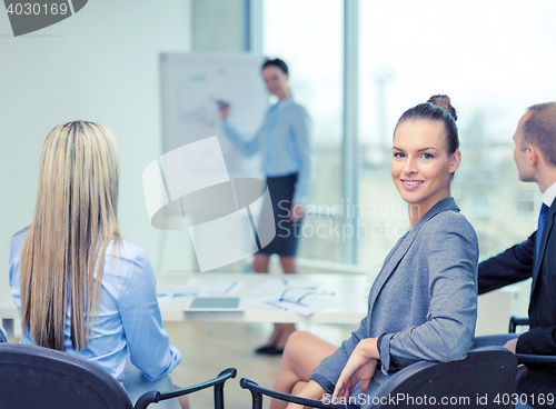 Image of businesswoman with team showing in office