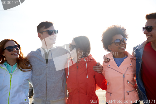 Image of happy teenage friends in shades talking on street