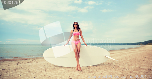 Image of smiling young woman with surfboard on beach