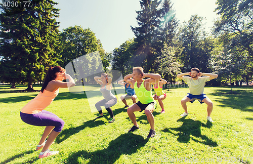 Image of group of happy friends exercising outdoors