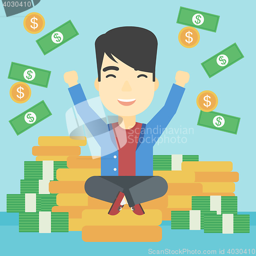 Image of Happy businessman sitting on coins.