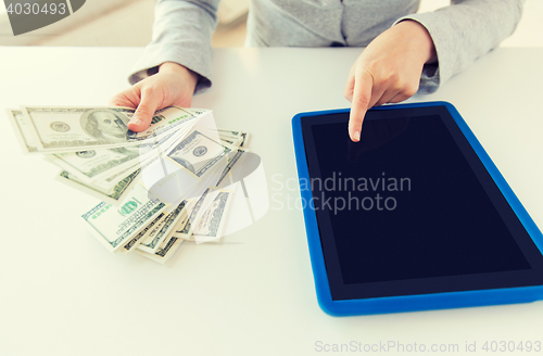 Image of close up of woman hands with tablet pc and money