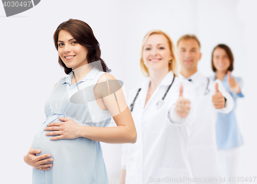 Image of happy pregnant woman touching her big belly