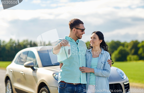 Image of happy man and woman with car key hugging 
