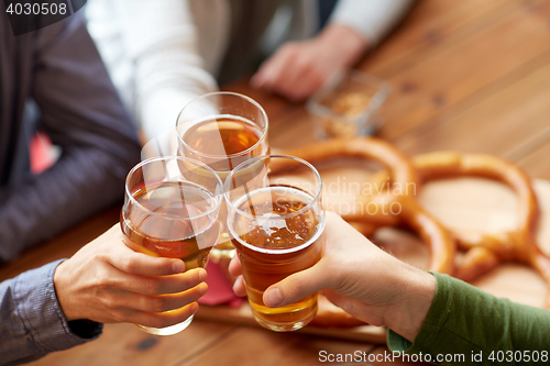 Image of close up of hands clinking beer at bar or pub