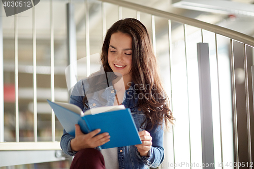 Image of high school student girl reading book at library