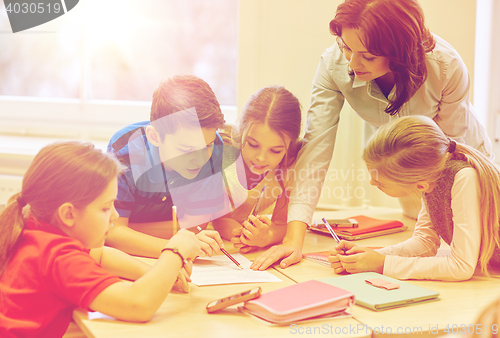 Image of group of school kids writing test in classroom