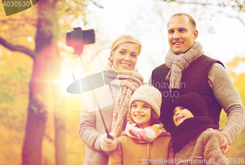 Image of happy family with smartphone and monopod in park