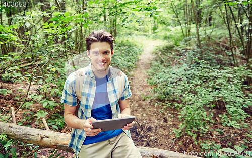 Image of happy man with backpack and tablet pc in woods