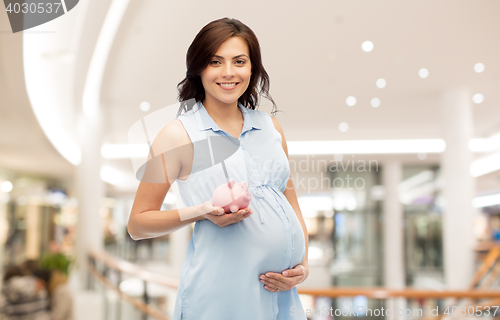 Image of happy pregnant woman with piggybank shopping