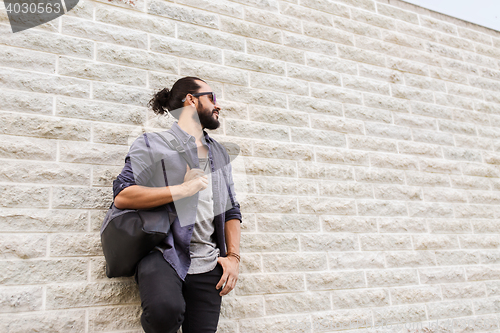 Image of man with backpack standing at city street wall