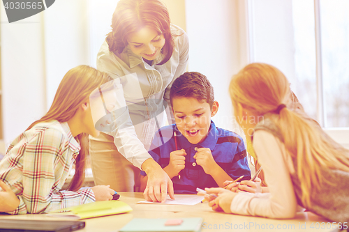 Image of group of school kids writing test in classroom