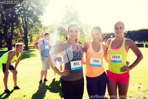 Image of happy young sporty women with racing badge numbers