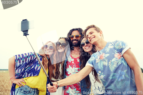 Image of hippie friends with smartphone on selfie stick