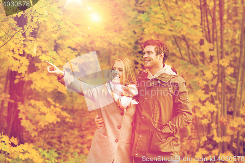 Image of smiling couple hugging in autumn park