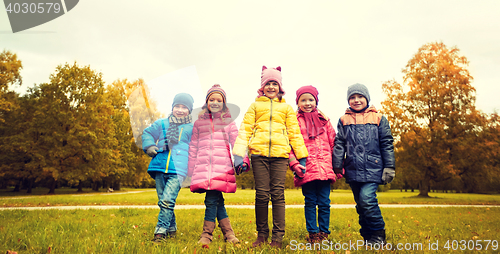 Image of happy children holding hands in autumn park