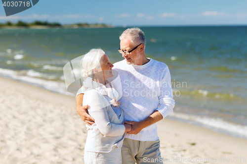 Image of happy senior couple holding hands on summer beach