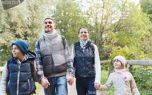 Image of happy family with backpacks hiking in woods