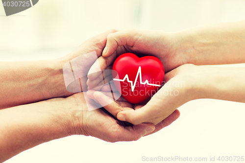 Image of man hand giving red heart to woman