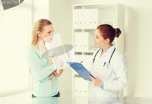 Image of woman with cat and doctor at vet clinic