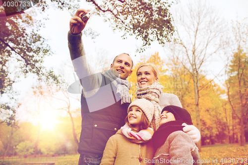 Image of happy family with camera in autumn  park