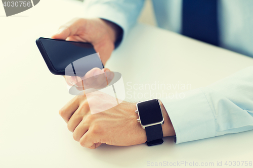 Image of close up of hands with smart phone and watch