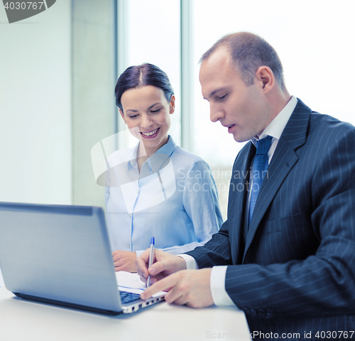 Image of business team with laptop having discussion