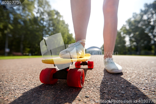 Image of close up of female feet riding short skateboard