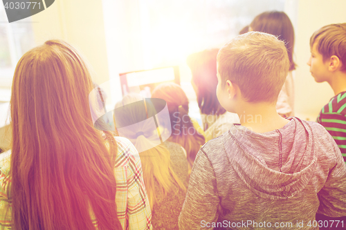 Image of group of kids with teacher and computer at school