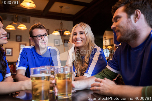 Image of football fans or friends with beer at sport bar