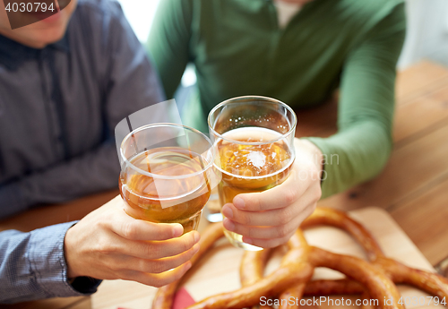 Image of close up of hands clinking beer at bar or pub