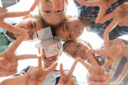 Image of group of happy children showing v sign in circle