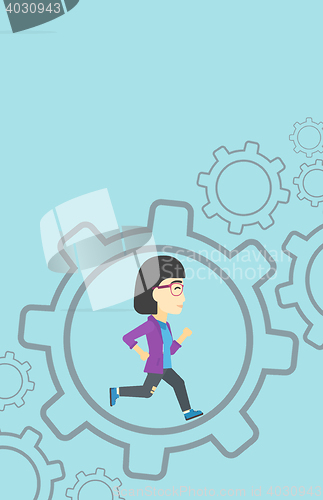 Image of Business woman running inside the gear.