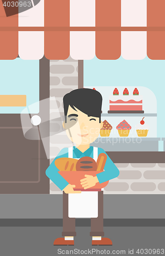 Image of Baker holding basket with bakery products.