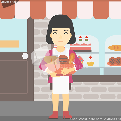 Image of Baker holding basket with bakery products.