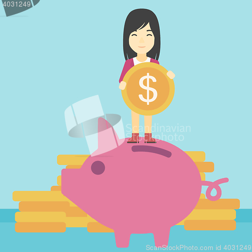Image of Business woman putting coin in piggy bank.