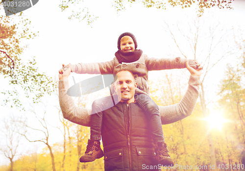 Image of happy family having fun in autumn park