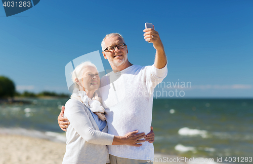 Image of happy senior couple hugging on summer beach