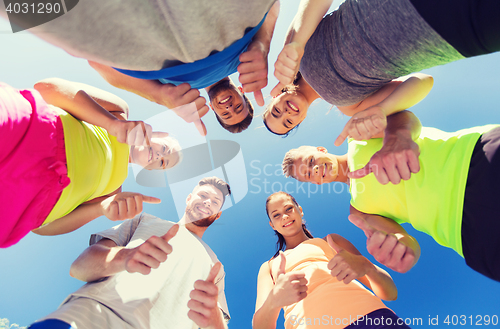 Image of group of happy sporty friends showing thumbs up